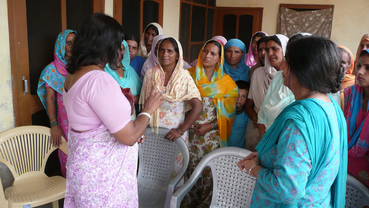 A group of Asian women dressed in saris and headscarves.