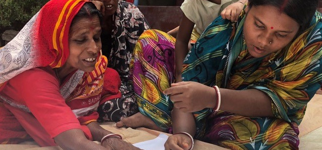 Two women writing and looking over a document. 