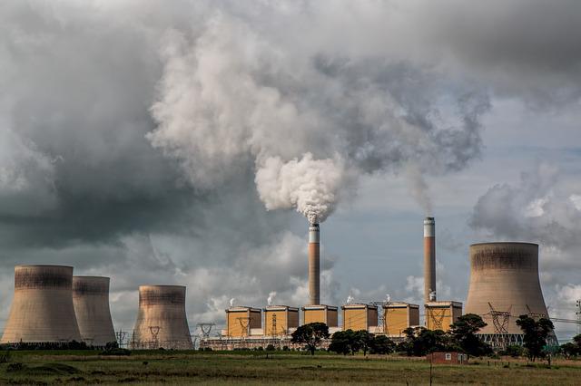 Industrial chimneys vent fumes into a stormy sky