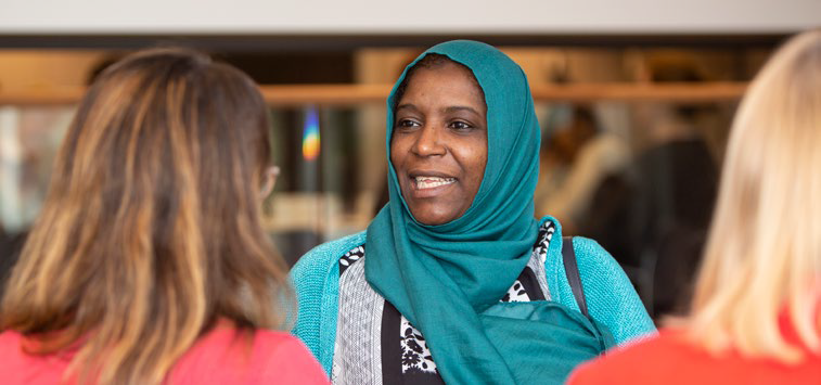 Three women talk in a study area